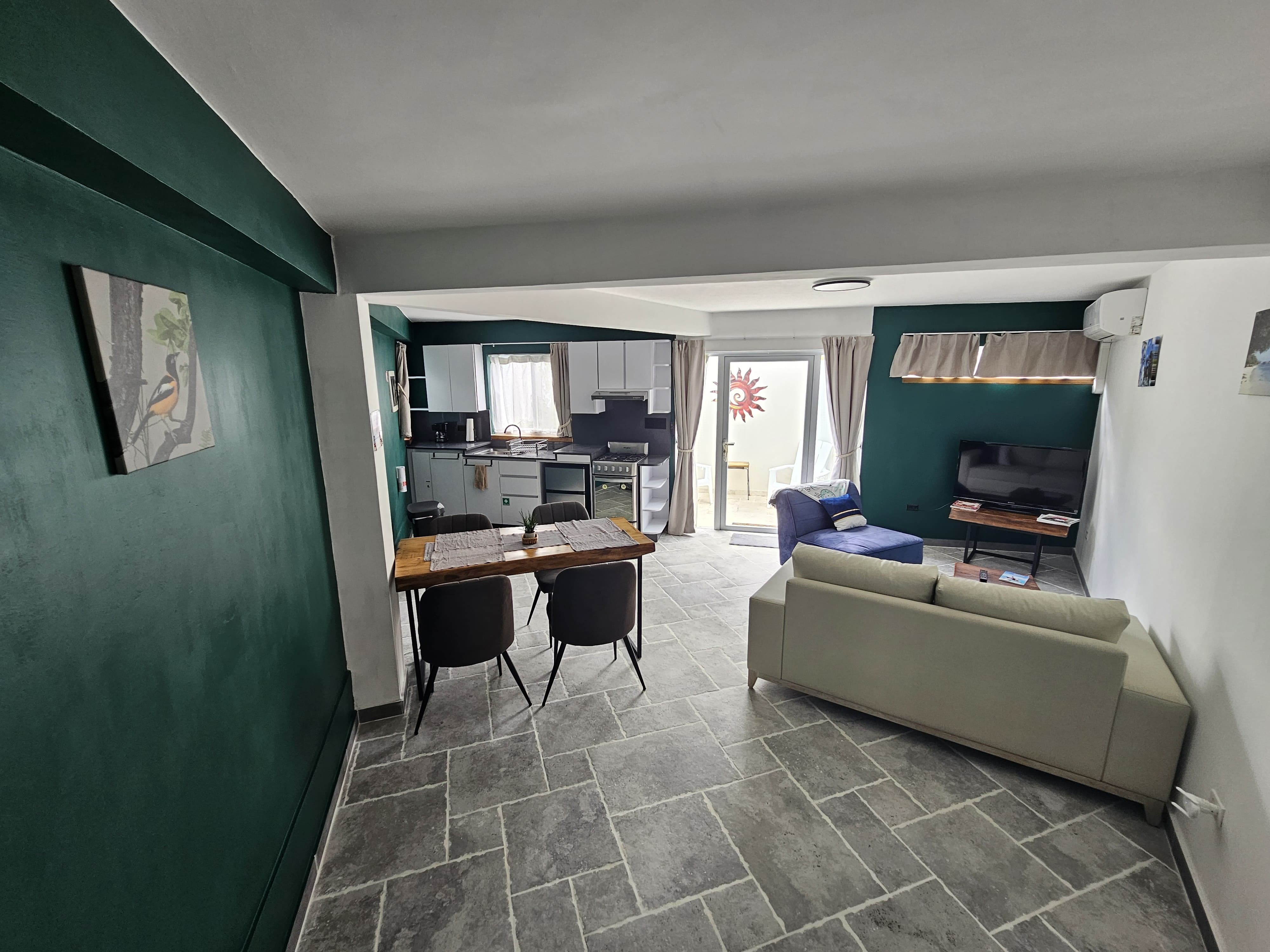 Woonkamer met groene muur en eettafel